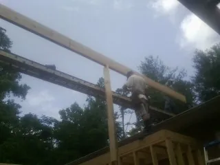 Carpenter setting a ridge beam over a new addition frame — Ice Dam Removal by Roofing Brothers in Rockford